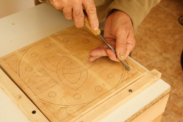 El alumno tallando el motivo geométrico sobre la madera