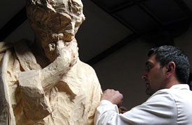 El escultor trabajando la talla con la silueta traspasada