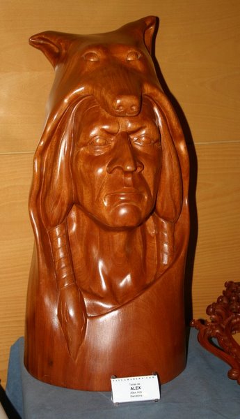 Talla en madera de un rostro indígena con un oso, presentada al concurso