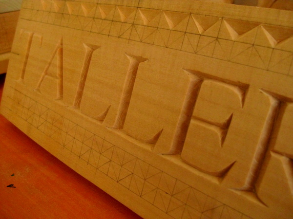 El cartel «TALLER» tallado en bajorrelieve, de cerca