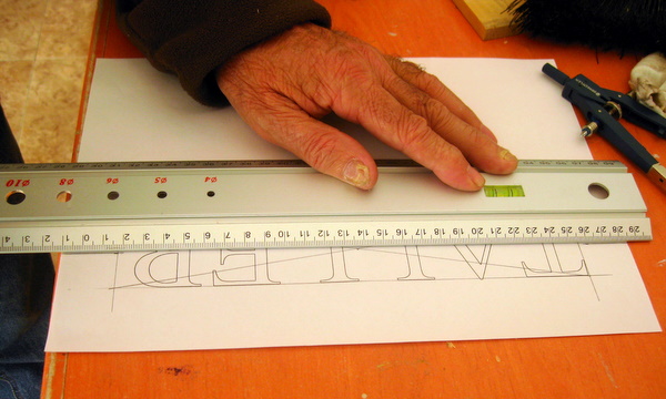 Repasando el dibujo con la regla de acero antes de calcar
