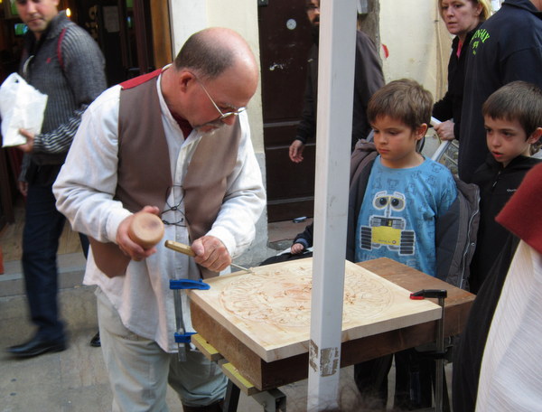 Un tallista tallando ante el público en una feria