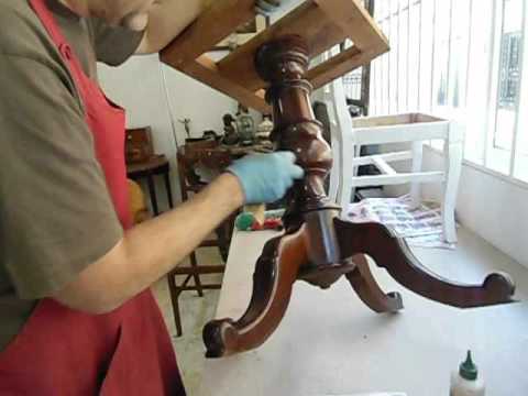 Aplicando goma laca a un mueble con muñequilla (fotograma del vídeo)